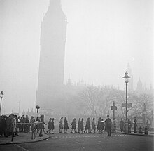 Een agent helpt mensen met oversteken Op de achtergrond is Big Ben te zien, Bestanddeelnr 254-1954.jpg
