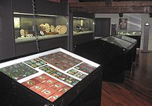 Inside the Museum of Precinema. Glass magic lantern slides and optical toys for early animation are displayed behind glass, and there are two reproduction stereoscopes in the background.