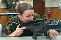 A female soldier of the British Royal Air Force checking a M60