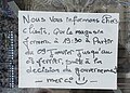 Affiche dans une porte de dépanneur indiquant la fermeture à 19h30 en raison du couvre-feu