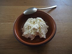 Photographie d'un fromage frais dans un récipient.