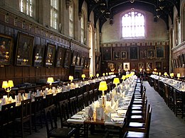 interior of large mediaeval building with tables and benches