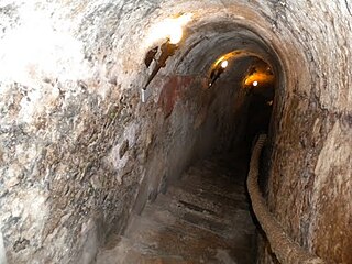 Looking down the stairs that are cut into solid rock at an underground Wine Cave in Aranda de Duero, Spain.