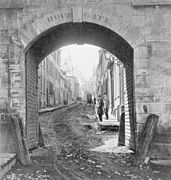 Vue rapprochée de l'extérieur de la porte Hope avant sa démolition vers 1871 et vue sur la rue Sainte-Famille de l'autre côté
