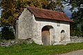 A gate with sundial on in the churchyard wall.