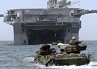 Un véhicule amphibie AAV-7 devant le radier inondable de poupe de l'USS Bonhomme Richard, s'apprêtant à enradier.