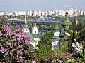 Lelà fil-Ġnien Botaniku Nazzjonali, bil-Monasteru Vydubychi, il-Pont Ferrovjarju Darnitskiy u Kyiv fuq ix-xatt tax-xellug viżibbli fl-isfond