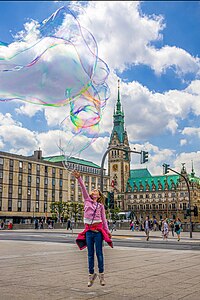 Kind versucht Riesenseifenblasen vor dem Hamburger Rathaus zu erreichen Foto: Hansfotos