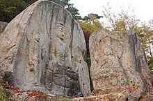 Five Buddhas carved into two natural rocks.