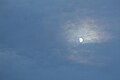 Rainbow-like clouds surround the moon