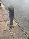 Wooden bollard painted grey, some paint is worn away