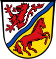 Landkreis Rottal-Inn Durch einen schmalen, nach links gerichteten blauen Wellenschrägbalken geteilt von Silber und Gold; oben ein Feuer speiender roter Panterrumpf, unten ein nach links gerichtetes steigendes rotes Pferd.