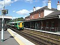 Station buildings with a Portsmouth-bound train arriving at Platform 2 in the foreground.