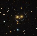 Εικόνα «γελαστού προσώπου» στο σμήνος γαλαξιών SDSS J1038+4849 με έναν δακτύλιο του Αϊνστάιν.[41]