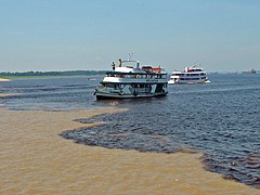 Turisteja kuljetetaan veneillä katselemaan yhteenvirtausta.