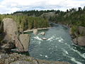 A stream of water in front curving around some large boulders