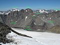 Die Fundstelle des Manns vom Tisenjoch (Ötzi) in der Gebirgswelt der Ötztaler Alpen. Das Bild wurde beim Aufstieg zum Similaun aufgenommen und zeigt den Blick Richtung Nordwesten. Die Gegend des Fundorts ist als roter Punkt markiert.