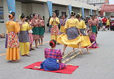 Tinikling (vagyis bambuszrúd-tánc). Gyorsan összecsapódó bambuszrudakat kell a táncosoknak taps és dobpergés közben átugrálniuk