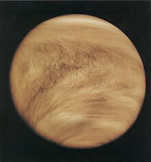 Lysebrune skyer viklet omkring en planet, set fra rummet / Light brown clouds wrap around a planet, as seen from space.