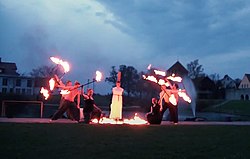 Grupp med studenter som uppträder med eldshow på valborg i Almedalen, Visby, Sverige