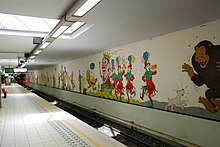 Personnages peints sur le mur blanc d'une station de métro.