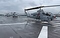 An AH-1W Super Cobra and S-70 Seahawk sit on the deck