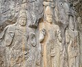 The crowned figure at the centre of the group is thought to be Maitreya, the future Buddha. To his left stands Vajrapani, who holds a vajra (an hourglass-shaped thunderbolt symbol) – an unusual example of the Tantric side of Buddhism in Sri Lanka. The figure to the left may be either Vishnu or Sahampath Brahma. Several of the figures hold up their right hands with two fingers bent down to the palm – a beckoning gesture.