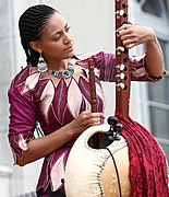 Sona Jobarteh tuning a kora with open machine heads