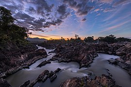 Cascades de Li Phi (chutes de Khone) au crépuscule avec un ciel coloré et des nuages.