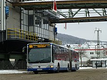 Gelenkbus mit Schwebebahnsymbol als Linie unter dem Schwebebahngerüst