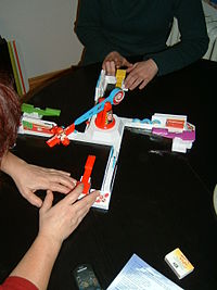 Zwei Erwachsene spielen Looping Louie