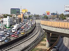 An image of the track system for Oceanía, where the Line 5 rails are located at grade, while Line B's are in an elevated viaduct.