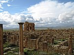 A picture of a city ruins and a still-standing building near the back.