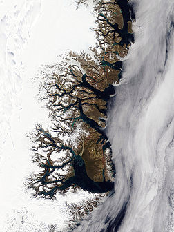 Photographie satellite en couleurs réelles (Terra MODIS) montrant l'organisation fractale de la côte est du Groenland et ses nombreux fjords. (définition réelle 2 400 × 3 200)