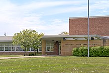 A low-slung, sandstone and red colored brick school building