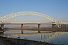 A arch bridge crossing a canal and river