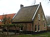 Boerderij waarvan het smalle, hoge voorhuis nog resteert, destijds behorend tot het kasteel Ter Weer, met later aangebouwd bedrijfsgedeelte