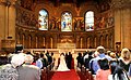 Wedding ceremony, California, with audience, couple, and officiator, in a church (behavior: marriage rites)