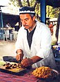 Tajik man preparing a popular rice dish called plov (pilaf)