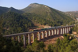 La locomotora dièsel-elèctrica 319.223 de Renfe Operadora, baixant amb un herbicida cap a Montcada, pel Viaducte del Buxadell.