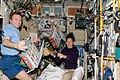 Sandra Magnus and Yury Lonchakov, Expedition 18, works with food storage container