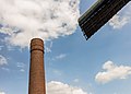 Fabrieksschoorsteen met langsdraaiende molenwiek.