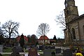 Die katholische Kirche Mariä Himmelfahrt neben dem Friedhof. Im Hintergrund rechts das alte Schulgebäude.