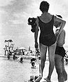 Een Japanse dame aan het strand met een Winky Doll aan haar schouder geklemd