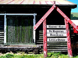 Welcome sign leaning against the goods shed of the former Little River Railway Station