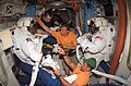 Robert L. Curbeam, Jr. and Sunita L. Williams, Expedition 14 flight engineer, get help as they remove their extravehicular mobility unit (EMU) spacesuits