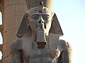 Nærbilde av en sittende kjempestatue Ramesses II inne i Luxortempelet