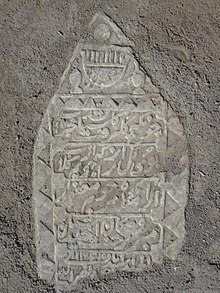 عکس از کتیبه نگاری بر روی یک قبر قدیمی، (شکل شانه بالای گور، نشانه ای از زن بودن صاحب آن است).