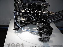 Photo d'un bloc moteur, exposé sur une table, dans un musée.