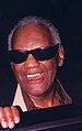 Photo of Ray Charles in one of his classic poses at the piano.